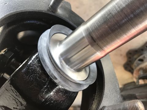 1989 Ford Bronco - A close-up view shows a metal shaft being inserted into a black, textured housing. A grey rubber seal is positioned between the shaft and t…