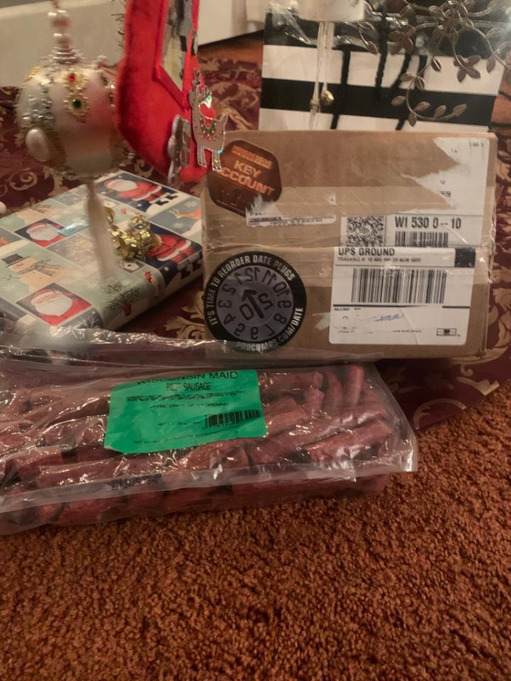 Wrapped gifts and a UPS shipping box on a carpet