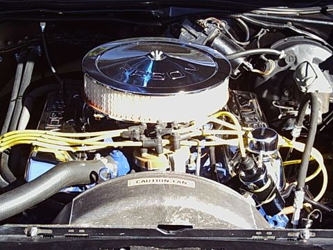 2000 Ford Taurus - Close-up of an engine bay a chrome air cleaner and yellow spark plug wires, with a 'CAUTION FAN' label visible.