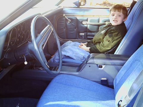 2000 Ford Taurus - Child sits in the driver's seat of a 1977 Ford Thunderbird, showing the car's interior.
