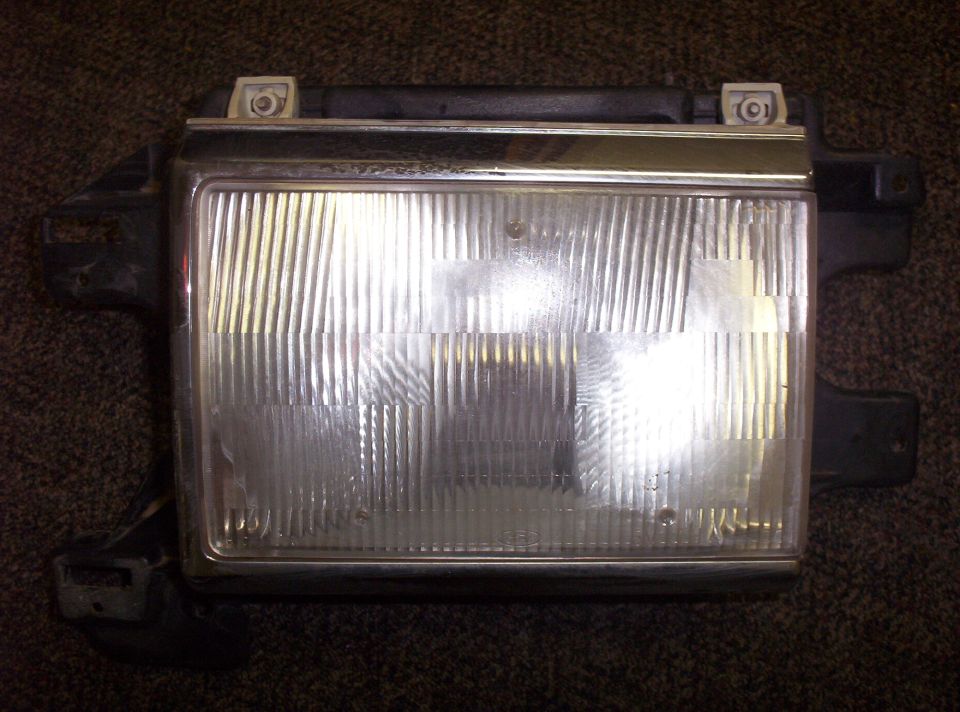 Headlight assembly with chrome trim and ribbed glass lens