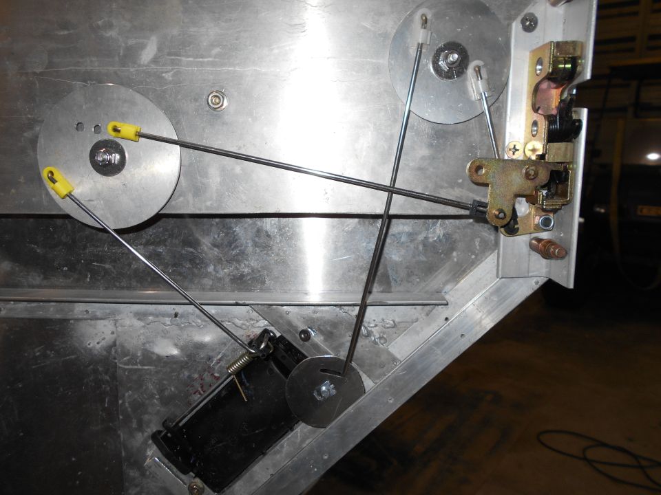 Vehicle door latch mechanism with cables and pulleys