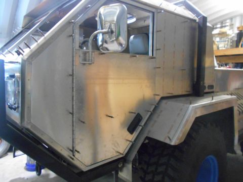 1992 Ford Bronco - A custom-built, unfinished vehicle with a brushed aluminum body is shown from a 3/4 front angle. The vehicle features a large side mirror,…