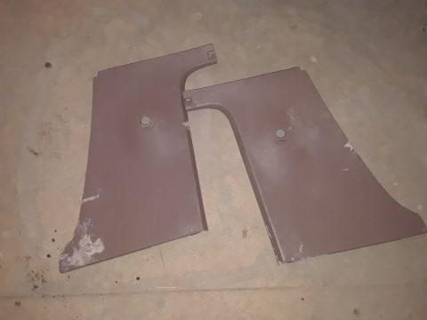 1994 Ford Bronco - Two brown plastic interior trim panels with circular mounting holes are shown on a concrete floor.