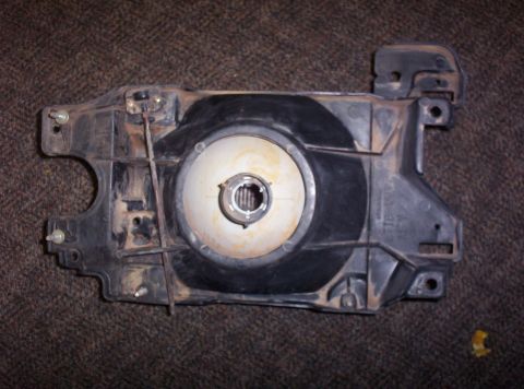 1988 Ford Bronco - A close-up view of a vehicle's headlight assembly, showing the internal components and mounting points.