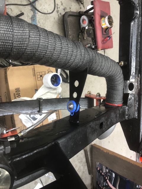 1992 Jeep Wrangler - Close-up view of a vehicle's exhaust pipe, covered in heat-resistant wrap and secured with a bracket.