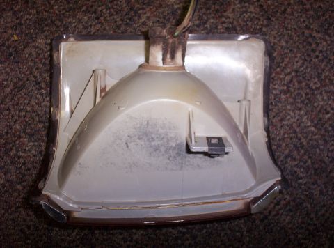 1988 Ford Bronco - The rear of a vehicle's turn signal housing is shown, with visible wiring and chrome trim.