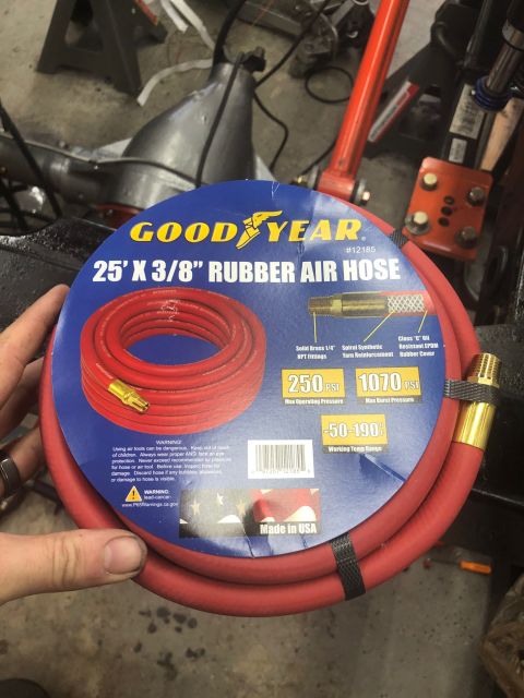 1992 Jeep Wrangler - A red Goodyear 25' X 3/8" rubber air hose is shown coiled on its packaging, which details its specifications and warnings.