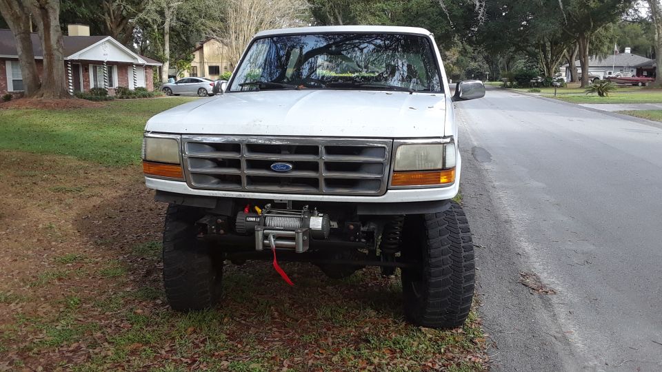 Lifted white 1994 Ford Bronco front view with winch