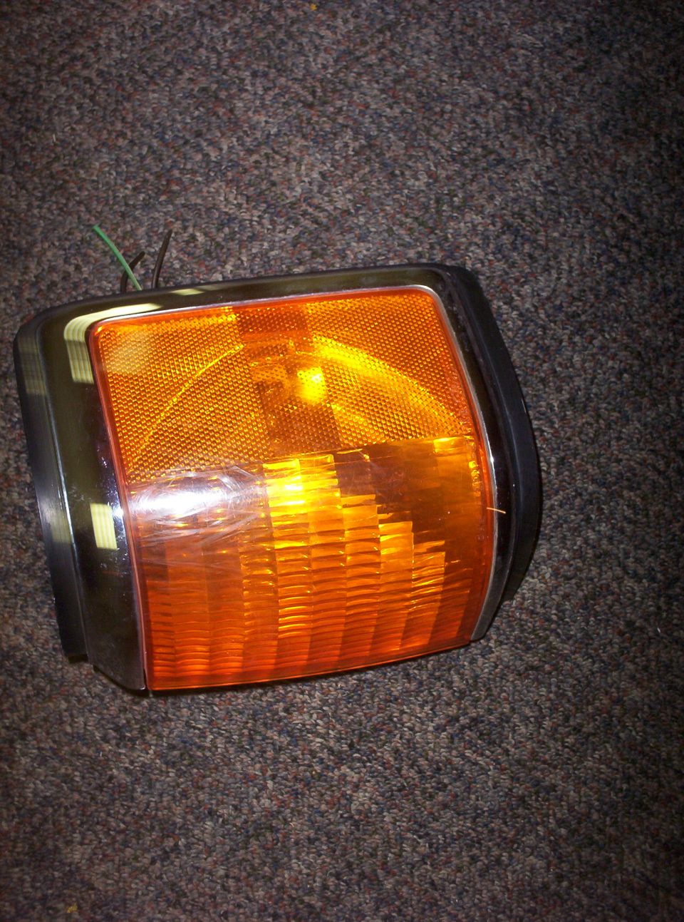 Orange turn signal light with chrome trim and wires