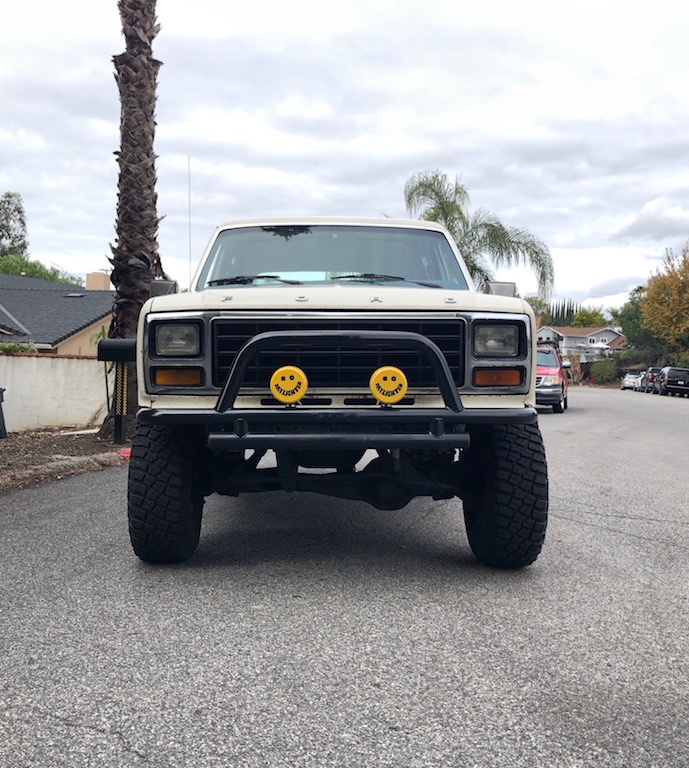 Lifted 1981 Ford Bronco front view with brush guard and smiley face lights.