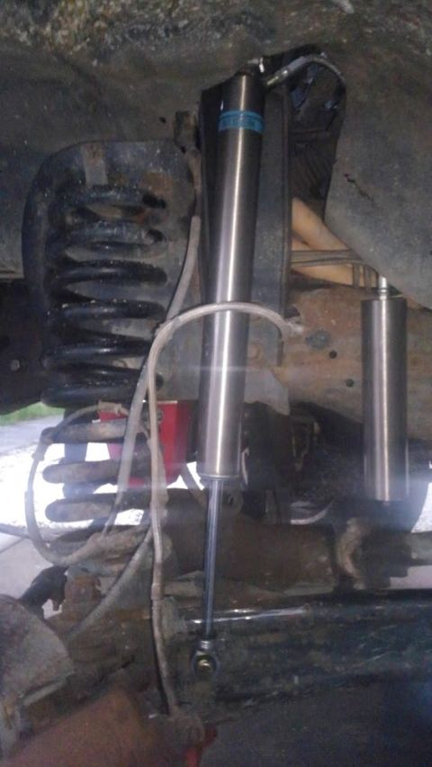 1996 Ford Bronco - Close-up view of a vehicle's suspension components, including a shock absorber and coil spring.