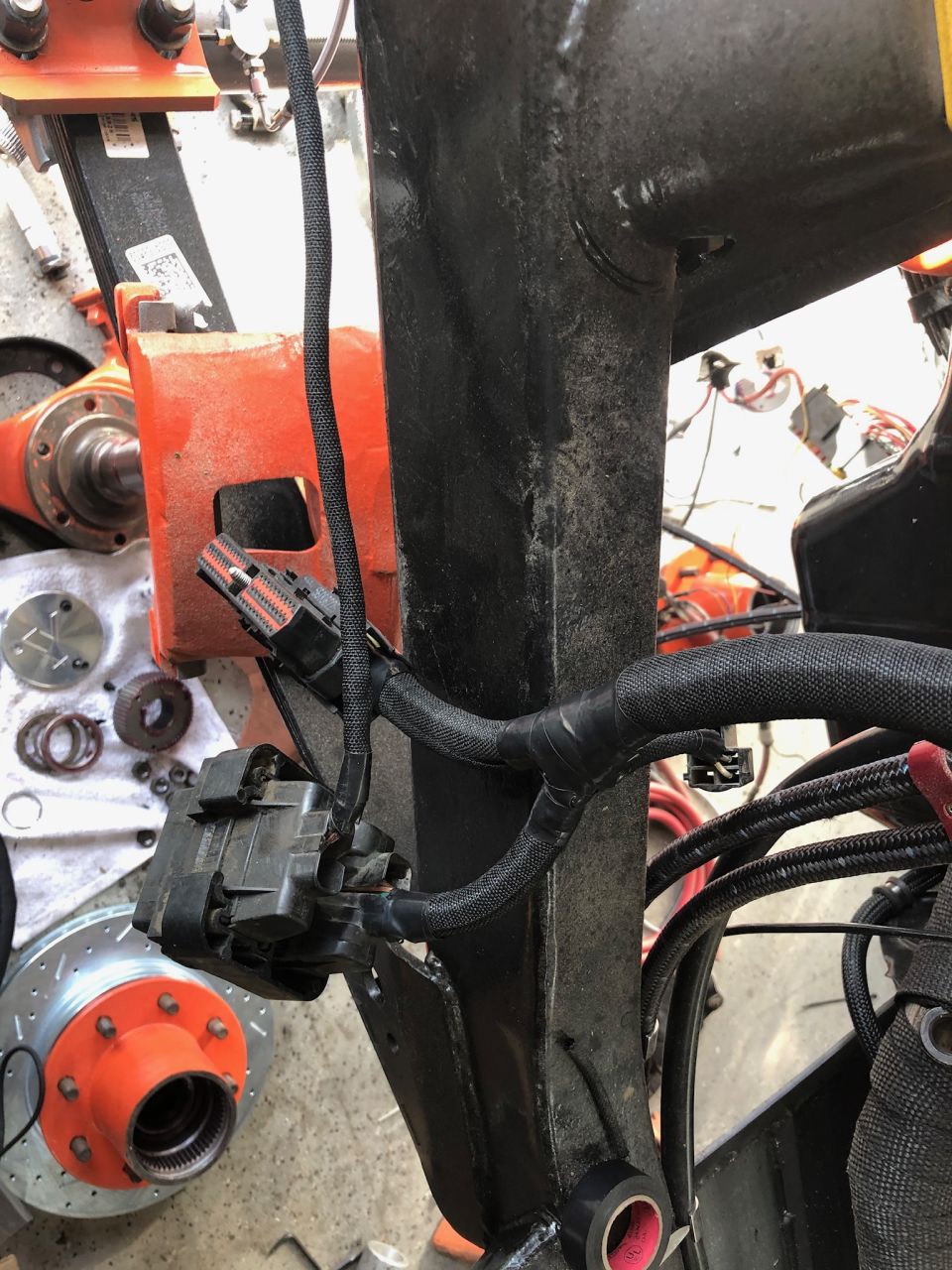 close-up of vehicle wiring harness and brake rotor with orange hub