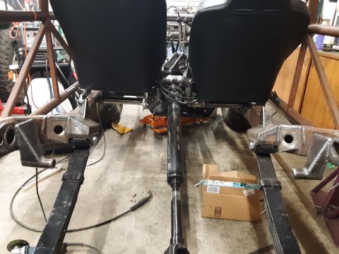 1985 Toyota Hilux - The interior and chassis of a vehicle undergoing modification, with two bucket seats and exposed mechanical components.