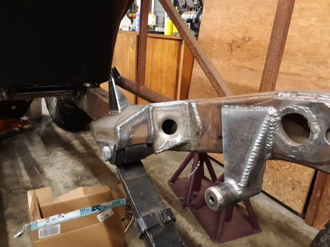1985 Toyota Hilux - A close-up view of a custom-welded frame section supported by jack stands, showing suspension components.