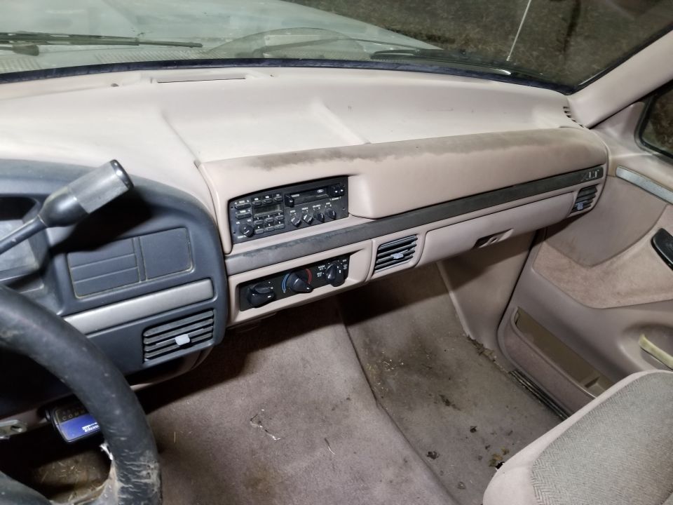 Interior dashboard of a 1995 Ford F-150, showing the radio, climate controls, and steering wheel