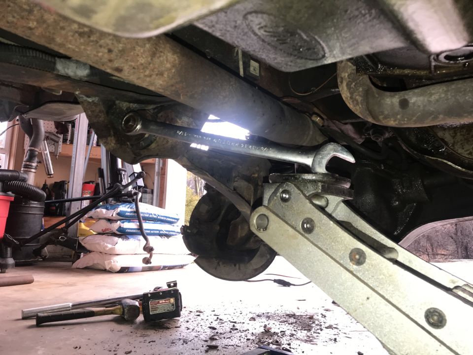 wrench on suspension part, jack holding up axle