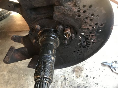 1994 Ford Bronco - Close-up of a heavily corroded wheel hub assembly, showing significant wear and damage to the rotor and mounting points.