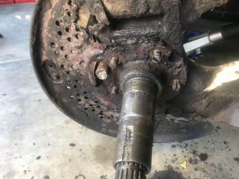 1994 Ford Bronco - This heavily corroded brake rotor and hub assembly shows significant wear and tear, indicating a need for replacement.