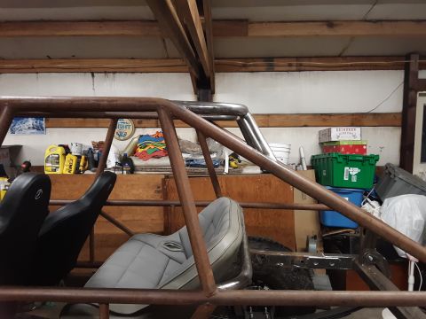 1985 Toyota Hilux - The interior of a custom-built off-road vehicle is shown, a prominent roll cage and two bucket seats. Text from a watermark reads SUPERMOTO…