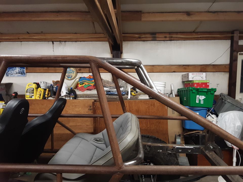 Interior of a custom off-road vehicle with roll cage and two seats. Visible text: SUPERMOTORS