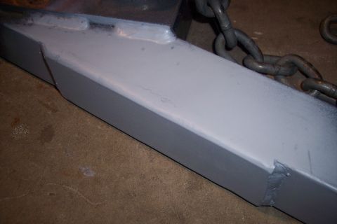 1973 Ford F-250 - Close-up of a painted metal frame section with a heavy chain attached, likely part of a repair or restoration project.