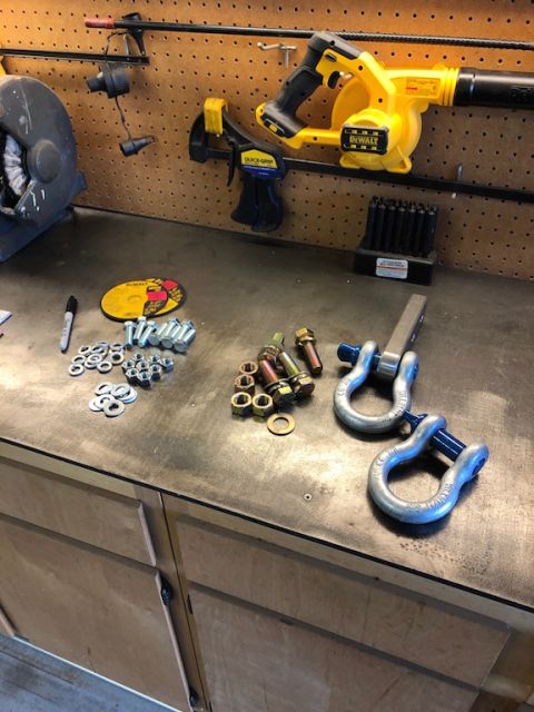 1981 Ford Bronco - A workbench is organized with various tools and hardware, including a blower, grinder, and tow shackles.