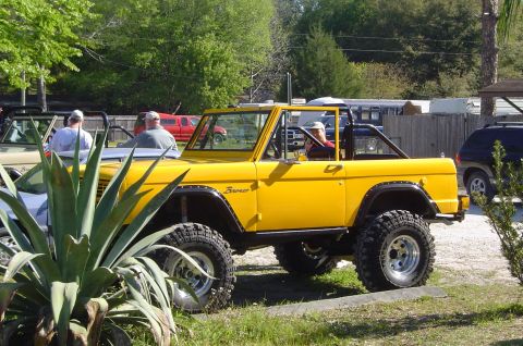 1974 Ford Bronco - A yellow Ford Bronco is parked outdoors with other vehicles nearby.