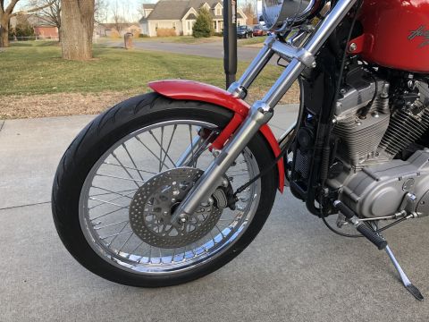 2002 Harley-Davidson Sportster Custom - Close-up of the front wheel and engine of a 2002 Harley-Davidson Sportster Custom.