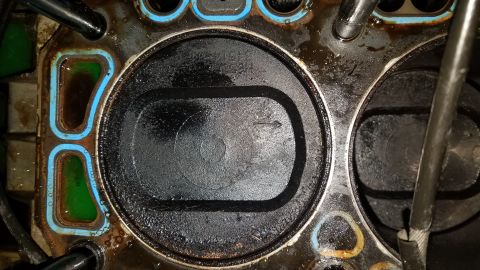 1985 Ford Bronco - Close-up view of an engine's cylinder head and piston, indicating internal engine work.
