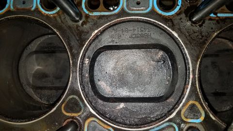 1985 Ford Bronco - Close-up of an engine block's cylinders and pistons, with visible part numbers and a manufacturing date of 1984.