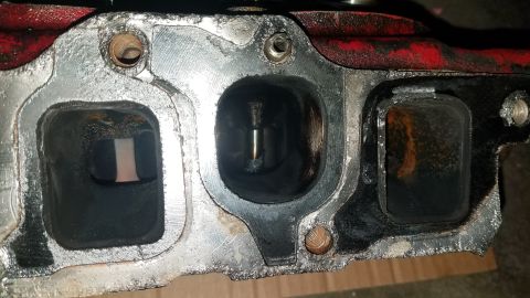 1985 Ford Bronco - Close-up of an engine intake manifold, revealing internal wear and carbon deposits.
