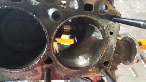 1985 Ford Bronco - Engine block cylinders showing wear and a tool being used for inspection or repair.