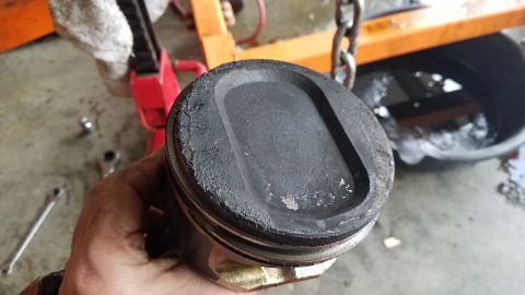 1985 Ford Bronco - A piston shows significant carbon deposits, indicating a need for engine repair or maintenance.