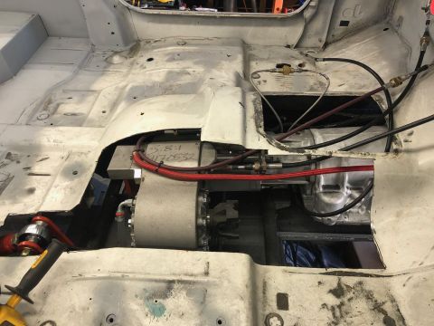 1992 Jeep Wrangler - The interior floor pan of a vehicle is shown with exposed drivetrain components, wiring, and hydraulic lines.
