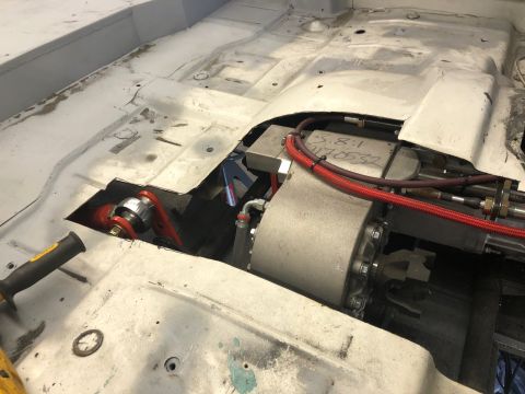 1992 Jeep Wrangler - Close-up view of a vehicle's interior, showing exposed drivetrain parts and red hoses during modification.