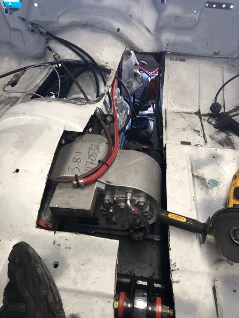 1992 Jeep Wrangler - Custom transmission tunnel modification with wiring and a grinder tool nearby.