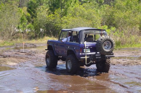1974 Ford Bronco - This modified Ford Bronco navigates a challenging muddy terrain.