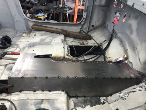 1992 Jeep Wrangler - The interior floor pan of a Jeep Wrangler is undergoing repair with a newly welded metal section.