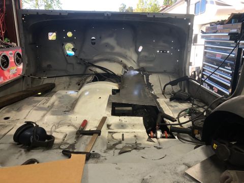 1992 Jeep Wrangler - The interior of a vehicle is shown stripped down and undergoing repairs, with tools scattered around the floor.