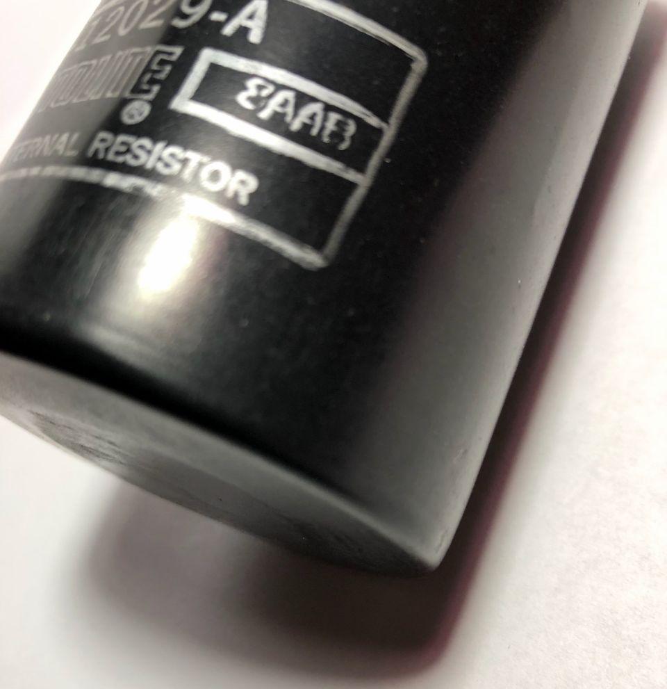 Close-up of a black automotive part with a label that reads "EXTERNAL RESISTOR" and some numbers
