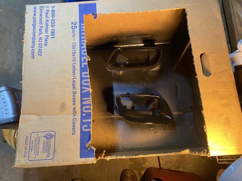 2000 Pontiac Grand Prix - Two car door handles are being painted inside a cardboard box. The box is from Paige Company.