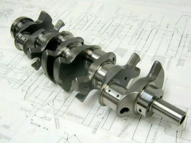 Engine crankshaft resting on technical blueprints with section A-A labeled