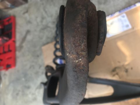 1994 Ford Bronco - Close-up of a heavily rusted vehicle suspension part, possibly from a Ford Bronco.