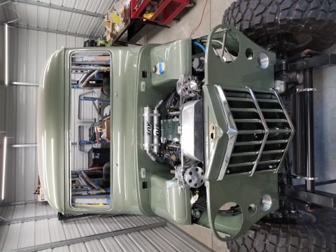 1949 Jeep Wagoneer - This truck is undergoing restoration in a garage, showing its engine and chassis details.