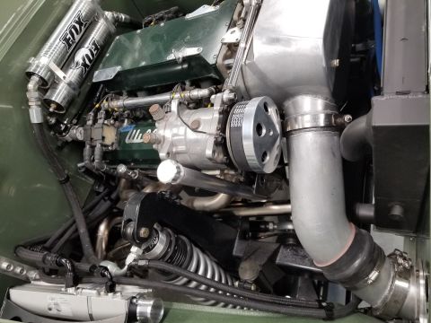 1949 Jeep Wagoneer - Custom engine bay features twin Fox shocks and prominent intake piping, with "Supermotors" branding visible.