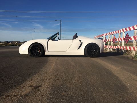 2015 Subaru Impreza - A white convertible sports car with black wheels is parked on the side of a road.