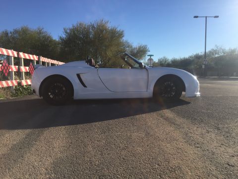 2015 Subaru Impreza - Side view of a white convertible sports car with black wheels.