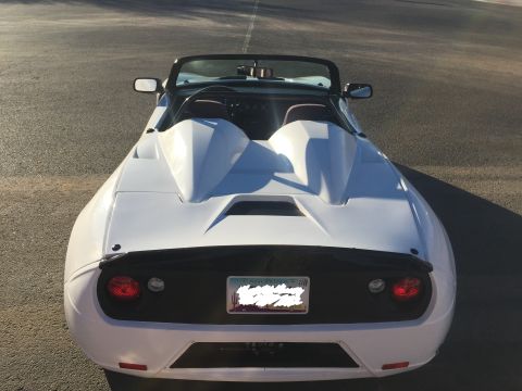 2015 Subaru Impreza - Rear view of a white convertible sports car with a black spoiler and dual humps behind the seats.