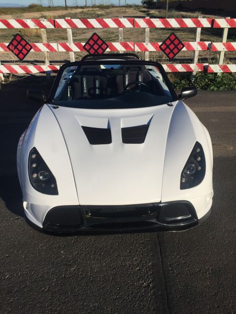 2015 Subaru Impreza - A white convertible sports car is parked in front of a red and white barrier.